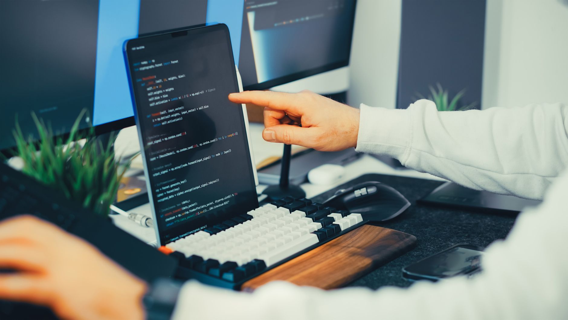 A developer who appears to be a senior engineer reviews code across multiple open tabs, intensely focused — the surrounding desks are empty