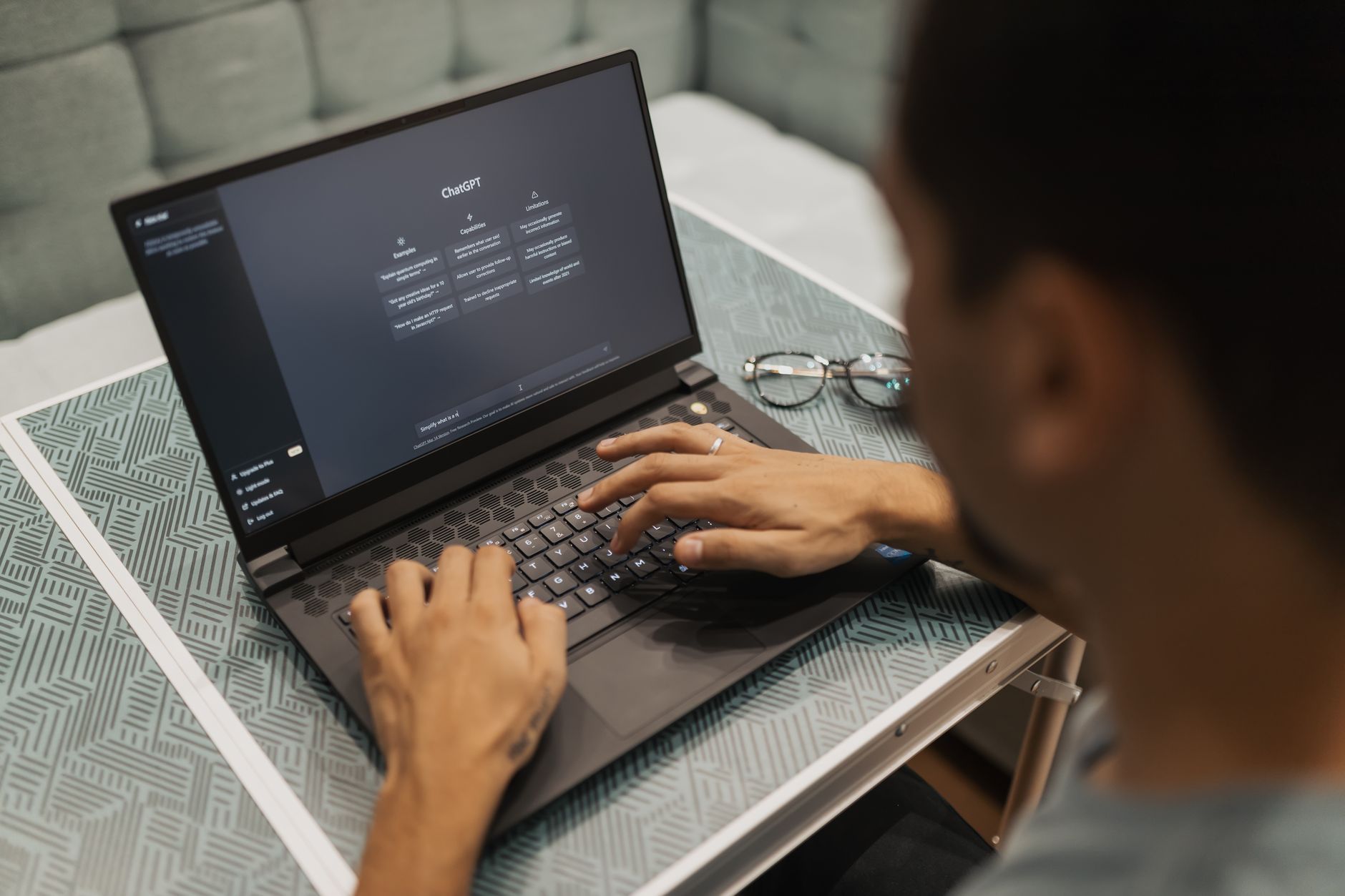 A quiet office scene showing a global procurement officer sitting at a laptop, reviewing a supplier list generated on an AI screen