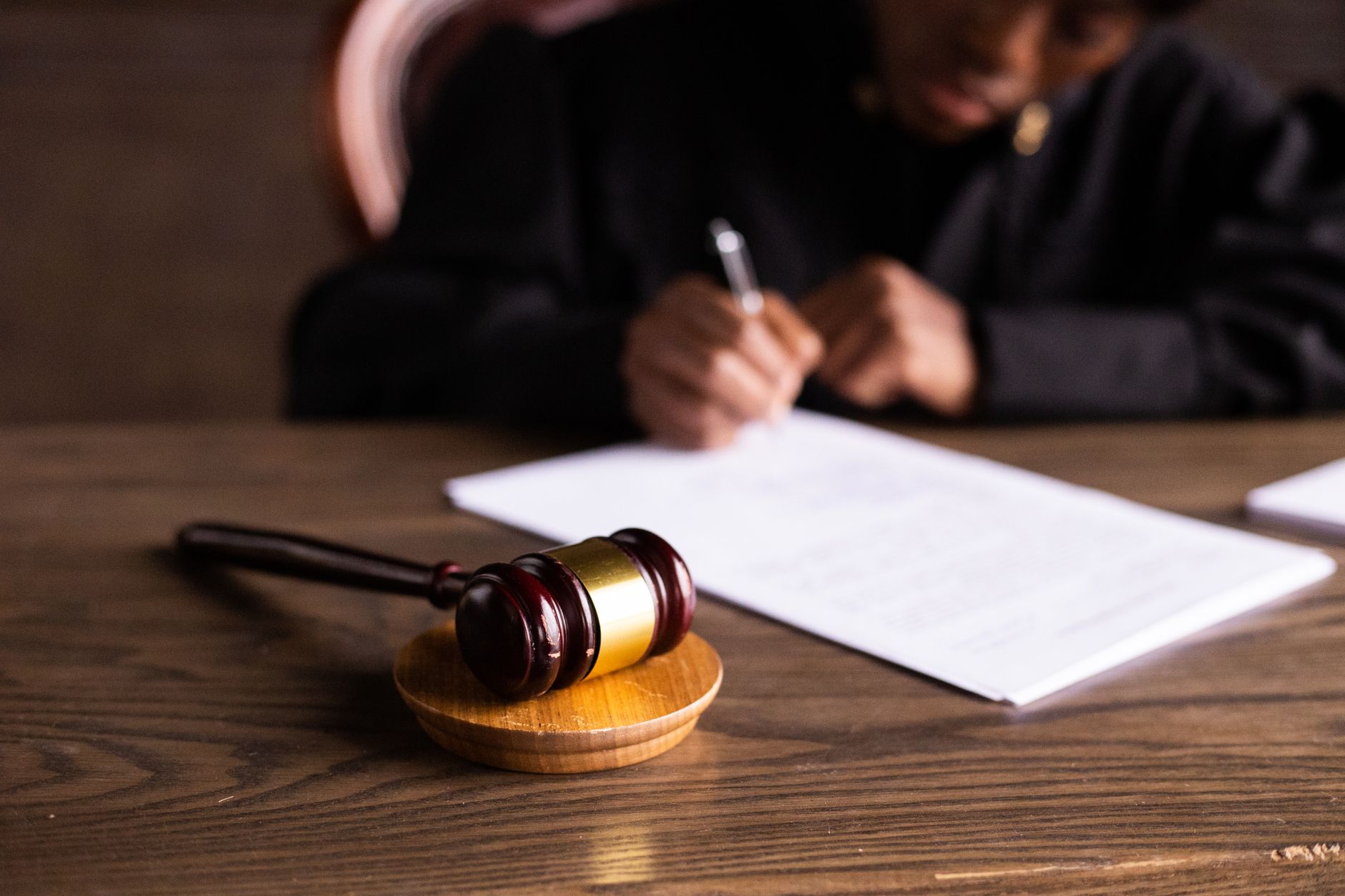 A judge's gavel placed on top of a pile of legal documents with the text 'First Amendment' visible, clean lighting