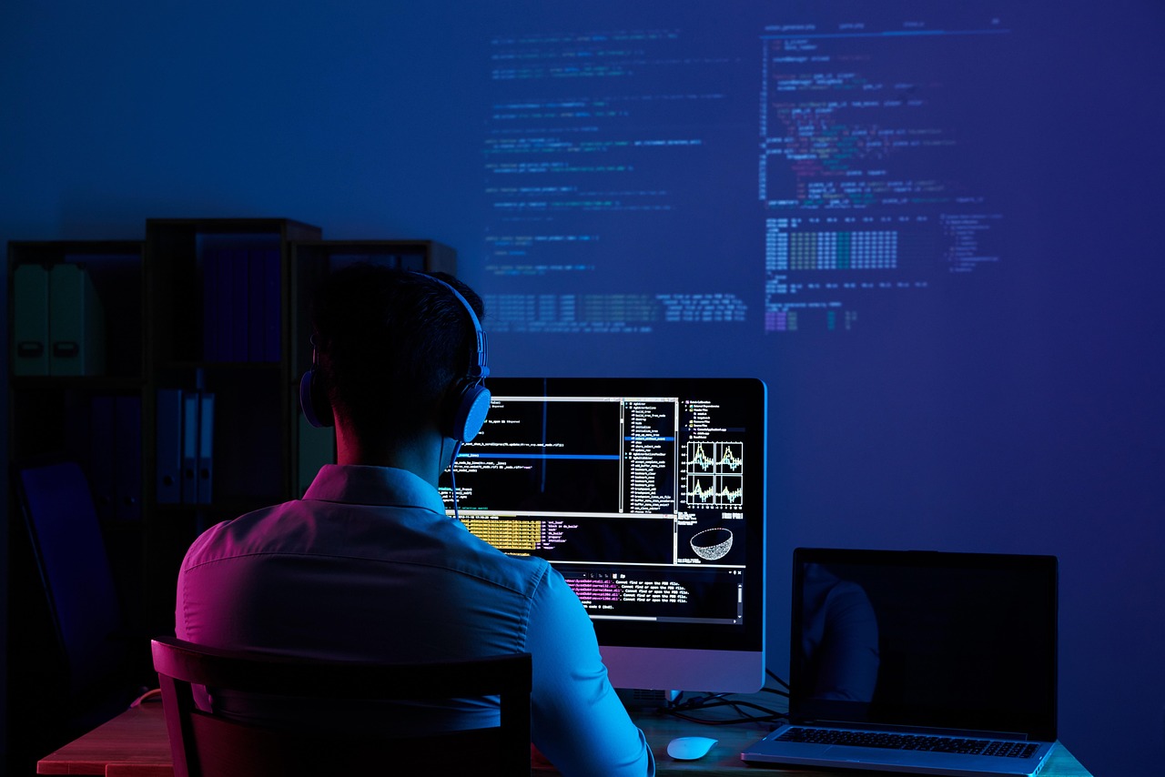 A developer checking a GitHub repository page on a laptop, looking at commit history and issue tracker, in a quiet office setting