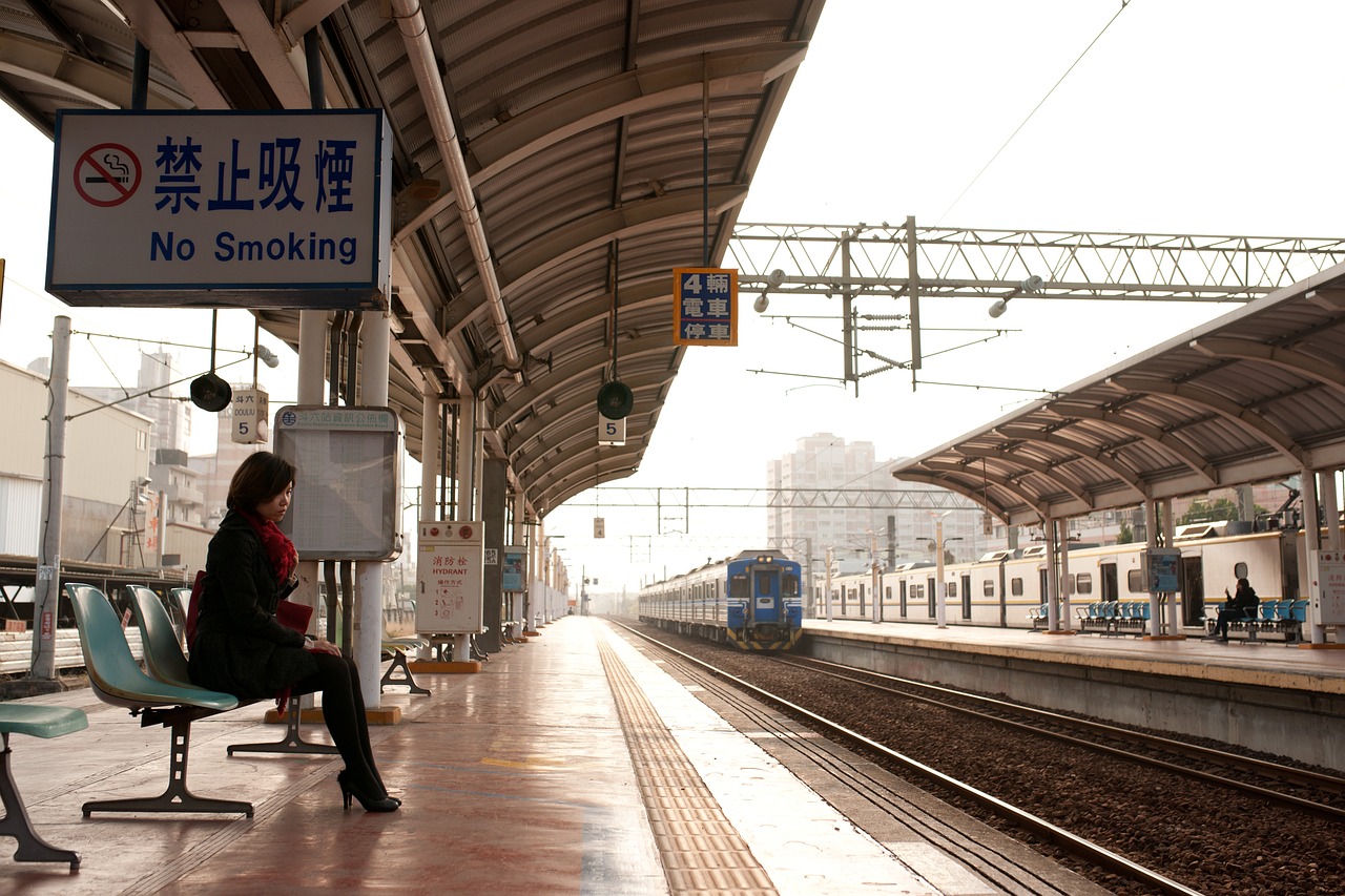 A traveler checking paper notes while looking at a train or public transit schedule board