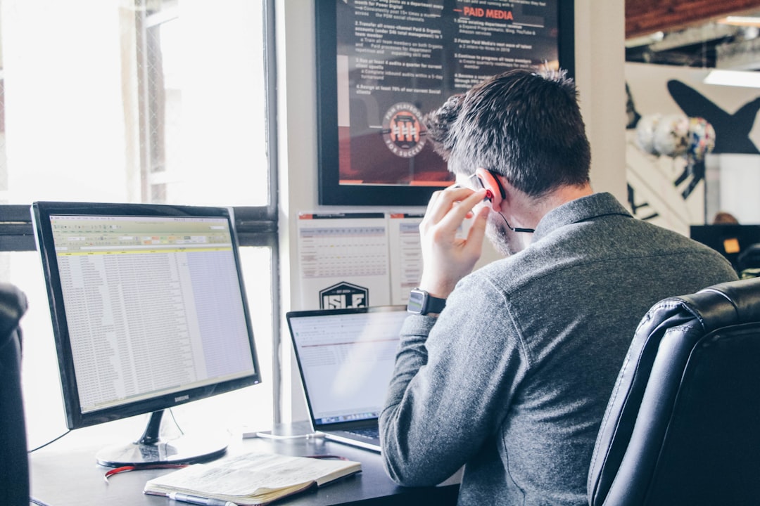 Image prompt: An office monitor showing two screens: one displaying the latest news articles from the buyer's country, and the other drafting a highly customized business proposal specifically for that buyer